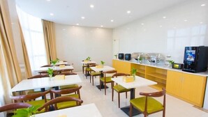 A modern dining area with white tables and chairs, a coffee station, and a view of the city. - Greentree Inn Cixi Zhouxiang Town Jiayue Plaza (Ningbo)