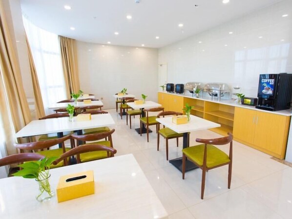 A modern dining area with white tables and chairs, a coffee station, and a view of the city. - Greentree Inn Cixi Zhouxiang Town Jiayue Plaza (Ningbo)
