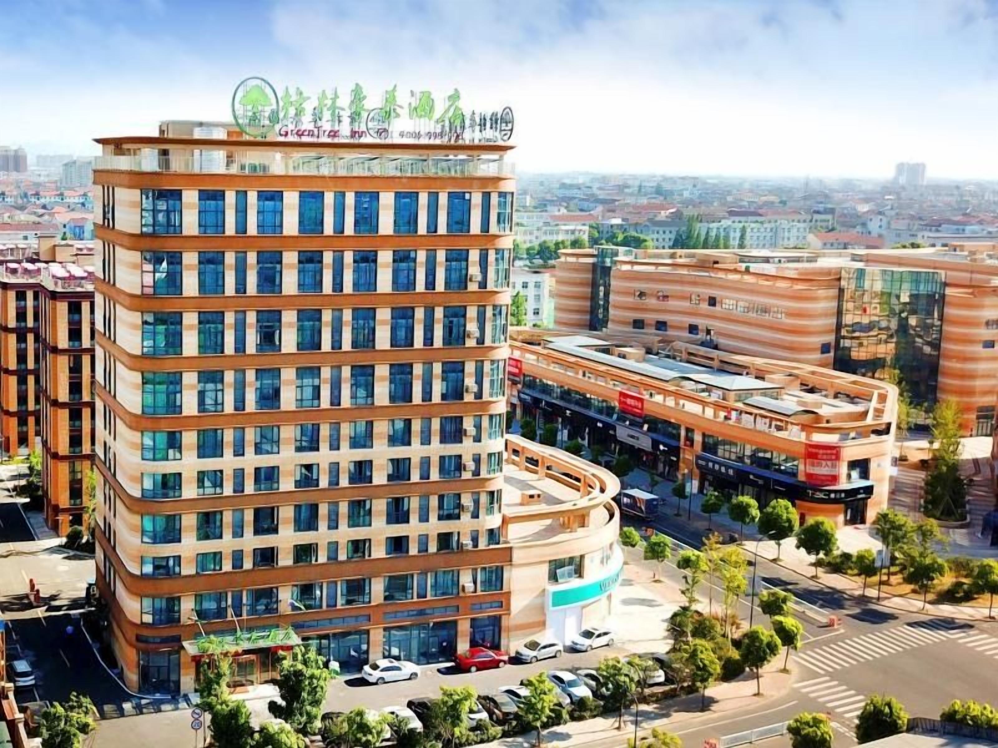 A modern hotel with a curved facade, multiple floors, and a rooftop sign.
