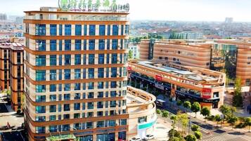 Un hotel moderno con fachada curva, varios pisos y un letrero en la azotea.