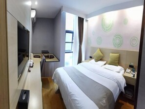 A hotel room with a bed, a desk, a chair, a TV, and a window. - Greentree Inn Suzhou Changshu Southeast Development Zone Southeast Avenue (Suzhou)