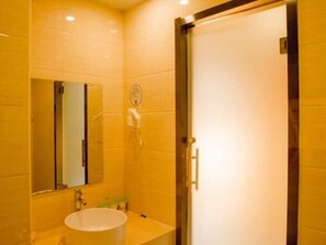A bathroom with a white sink, a mirror, and a glass shower enclosure. - Vatica Tianjin Wuqing District Cuihuang Town Hotel (Tianjin)