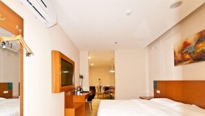 A hotel room with two beds, a desk, a chair, and a painting on the wall. - Greentree Inn Langfang Yanjiao Tianyang Plaza Expr (Langfang)