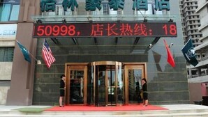 A hotel entrance with a revolving door, a red carpet, and flags. - Greentree Inn Langfang Yanjiao Tianyang Plaza Expr (Langfang)