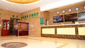 A hotel lobby with a reception desk, a chandelier, clocks, and a sign indicating 'Just Experience'. - Greentree Inn Langfang Yanjiao Tianyang Plaza Expr (Langfang)