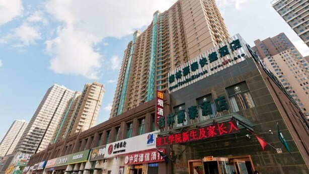 A high-rise building with multiple floors, featuring a prominent sign for a hotel and a restaurant. - Greentree Inn Langfang Yanjiao Tianyang Plaza Expr (Langfang)