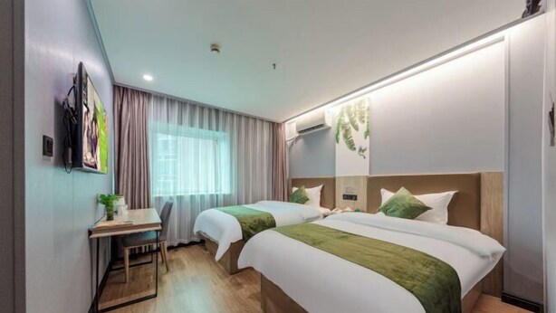 A hotel room with two beds, a desk, a chair, a TV, and a window with curtains. - GreenTree Inn (Shanghai Xuhui Xujiahui Yishan Road Metro Station) (Shanghai)