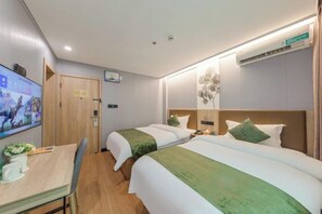 A hotel room with two beds, a desk, a TV, and an air conditioning unit. - GreenTree Inn (Shanghai Xuhui Xujiahui Yishan Road Metro Station) (Shanghai)