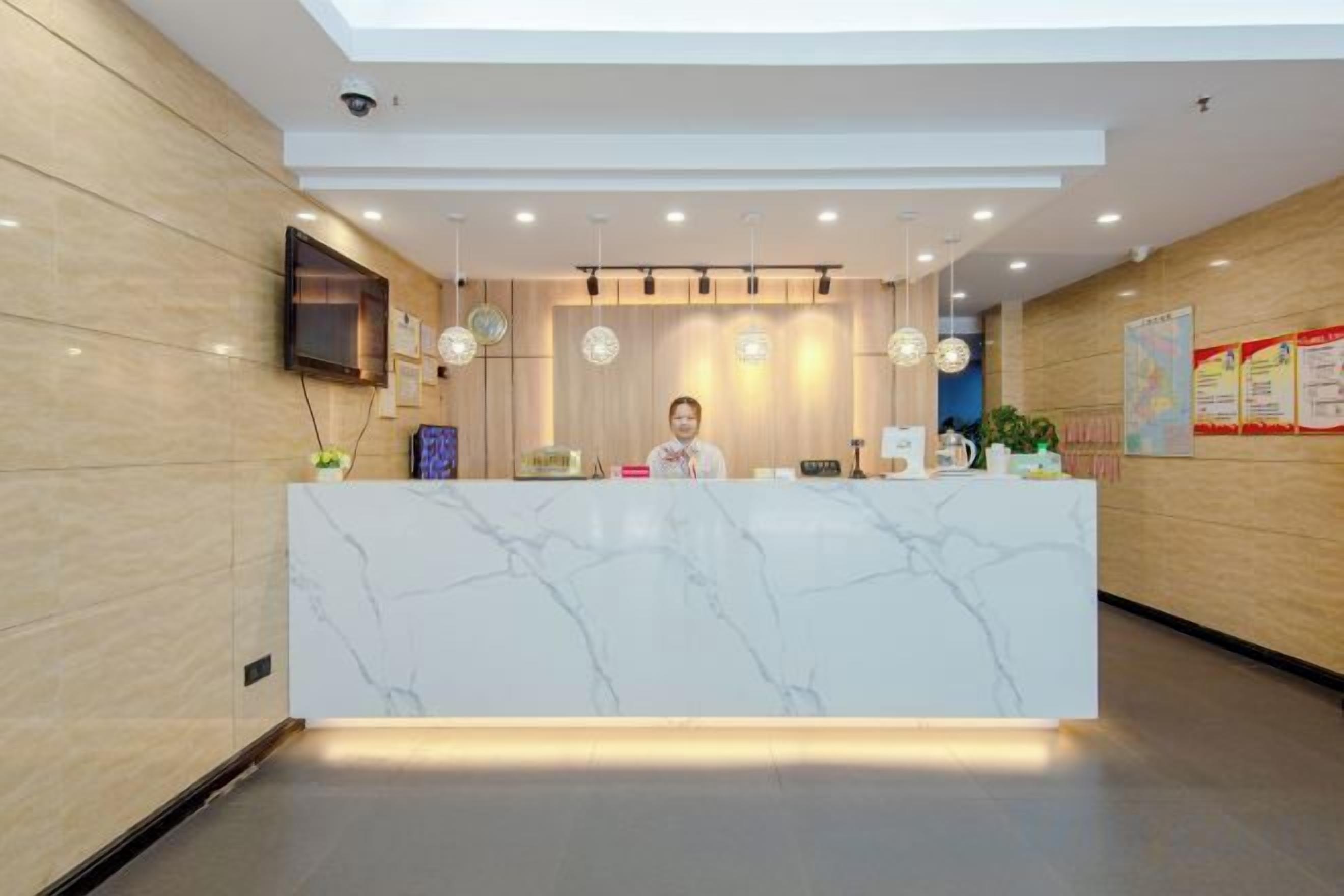 A reception desk with a marble top, a flat-screen TV, and a wall-mounted security camera.