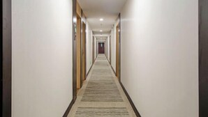 A long, narrow hallway with a carpeted floor and doors on both sides. - GreenTree Inn (Shanghai Xuhui Xujiahui Yishan Road Metro Station) (Shanghai)