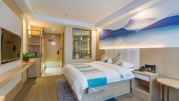 A modern hotel room with a large bed, a desk, a flat-screen TV, and a painting on the wall.