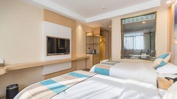 Une chambre d’hôtel avec deux lits, une télévision, un miroir et une fenêtre donnant sur une salle de bain.