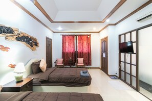 Un dormitorio con dos camas, televisión, cabecero de madera, estante en la pared y ventana con cortinas.