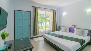 A hotel room with a bed, a TV, a window with curtains, and a door. - Chaiyo Resort Phuket by Zuzu (Wichit)
