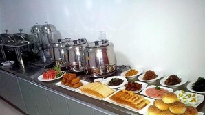A buffet with various food items including waffles, sandwiches, and salads.