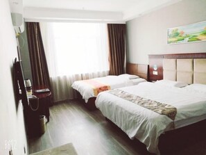 Une chambre d’hôtel avec deux lits, une tête de lit en bois, un tableau au mur et une fenêtre avec des rideaux.