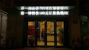A hotel entrance with a neon sign, a reception desk, and a visible room number. - Shell Shanghai Pudong New District Zhongke Road Hotel (Shanghai)