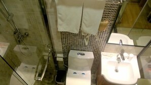 A bathroom with a glass-enclosed shower, a toilet, and a sink. - Shell Shanghai Pudong New District Zhongke Road Hotel (Shanghai)