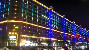 Un hôtel à plusieurs étages, doté d’une enseigne lumineuse et d’une rangée de fenêtres.