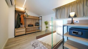 Une chambre moderne dotée d’une armoire intégrée, d’une rambarde en verre, d’un four à micro-ondes et d’une plante en pot.