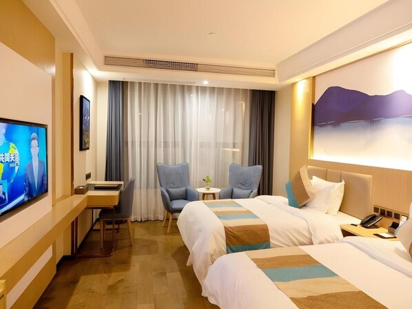 A hotel room with a bed, a desk, a chair, a television, and a painting on the wall.
