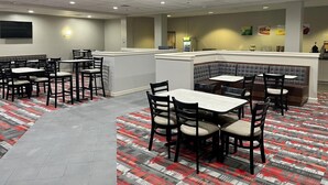 Un restaurant avec des banquettes, des tables et un comptoir.
