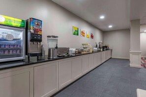 A breakfast bar with a refrigerated drink dispenser, a coffee machine, and a juice dispenser.