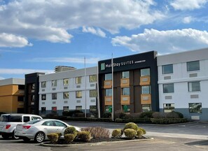 A hotel with multiple floors, a sign for 'MainStay Suites Extended Stay,' and a parking lot with cars.
