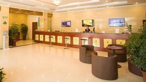 A hotel reception area with a modern design, featuring a reception desk, seating area, and a chandelier. - Greentree Inn Zaozhuang Tengzhou Fuqian Road Longquan Square Business Hotel (Zaozhuang)
