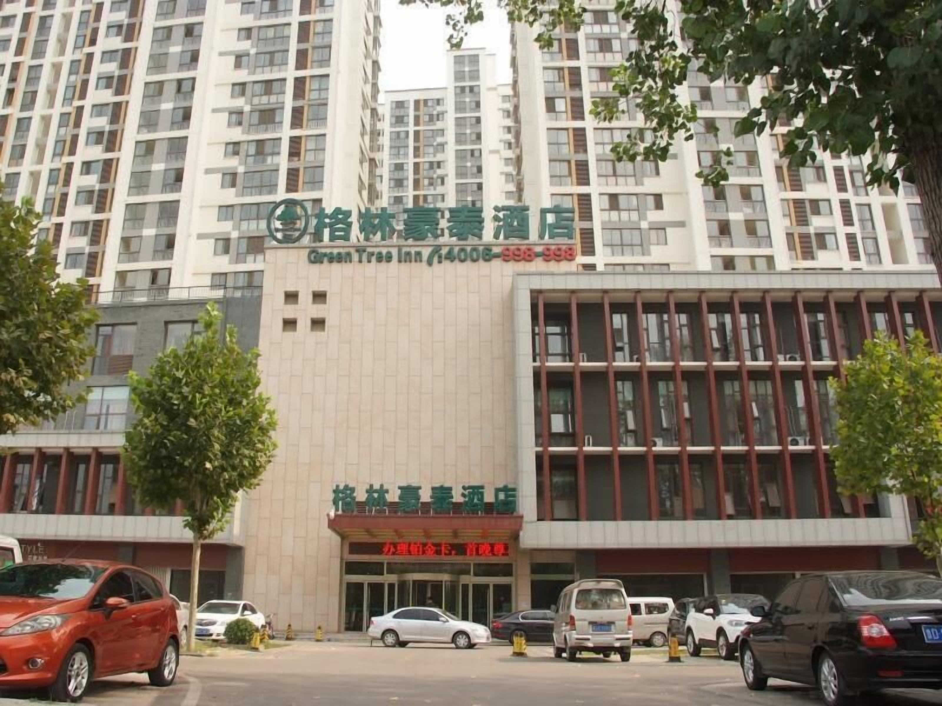 A hotel with a modern facade, multiple floors, and a prominent signage indicating it is the Green Tree Inn.