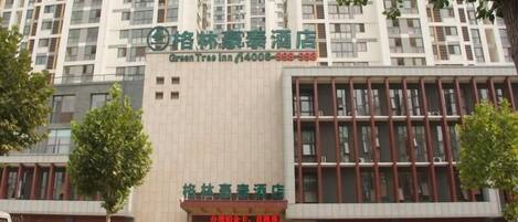 A hotel with a modern facade, multiple floors, and a prominent signage indicating it is the Green Tree Inn.