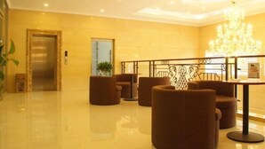 A lobby with a modern design, featuring a chandelier, seating area with round ottomans, and a reception desk. - Greentree Inn Zaozhuang Tengzhou Fuqian Road Longquan Square Business Hotel (Zaozhuang)