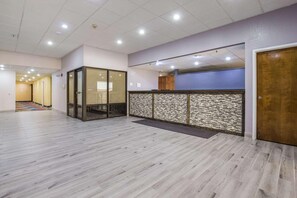 A reception area with a modern design, including a patterned wall and a wooden reception desk. - Quality Inn Grayville (Grayville)