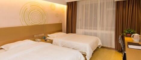 A hotel room with two beds, a desk, a chair, a telephone, and a window with curtains.