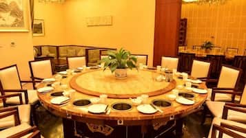 A round table with chairs, a potted plant, and a central decorative item.