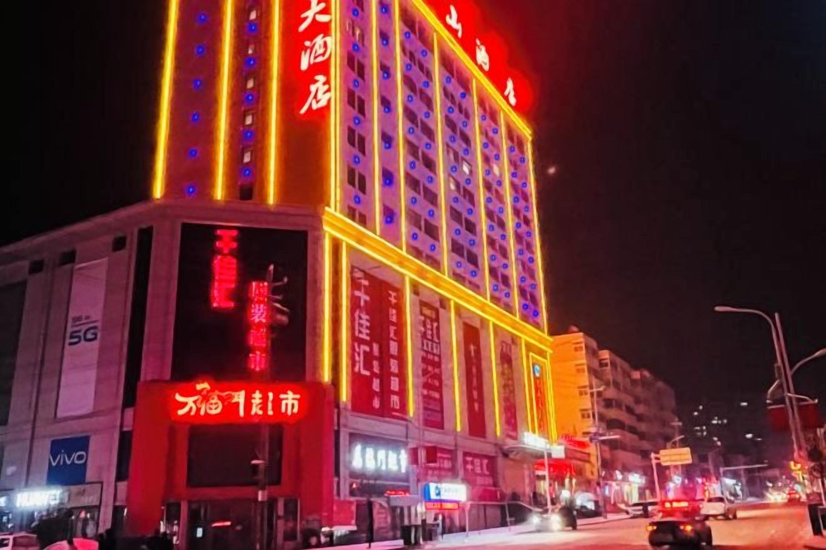 A multi-story hotel with illuminated signage, a prominent entrance, and a visible ground floor with signage.