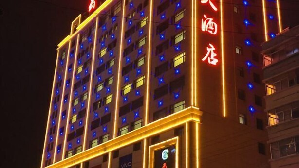 A multi-story hotel with illuminated signage and windows. - Yunshan Hotel (Jishishan)