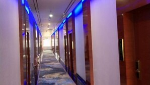 A hotel corridor with a carpeted floor and doors on both sides. - Yunshan Hotel (Jishishan)