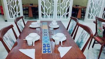 Mesa de comedor dispuesta con platos, tazones y una bandeja decorativa.