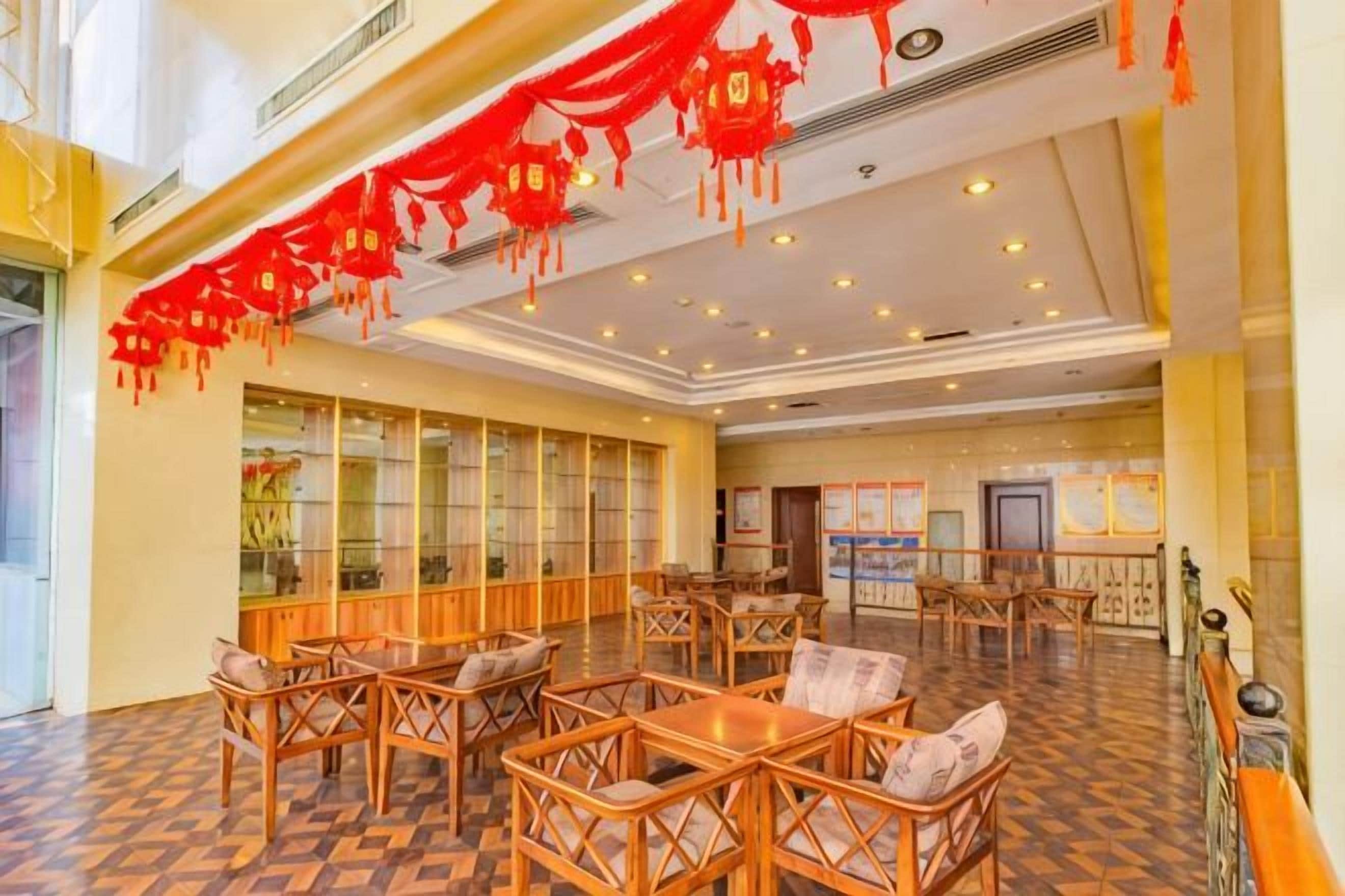 A spacious hotel lobby with wooden furniture and a checkered floor.
