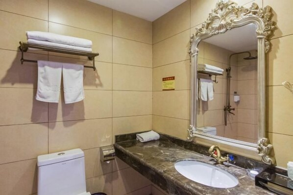 A bathroom with a marble countertop, a sink, a toilet, and a large ornate mirror. - Tian Yi Hotel (Zuoquan)
