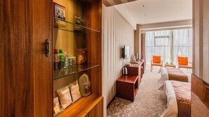 A hotel room with a wooden cabinet, a bed, a desk, and a television. - Tian Yi Hotel (Zuoquan)