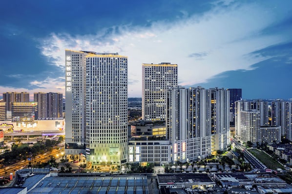 A high-rise building with multiple floors, large windows, and a prominent entrance. - Hampton by Hilton, Yuhang High Speed Railway Station, Hangzhou (Jiaxing)