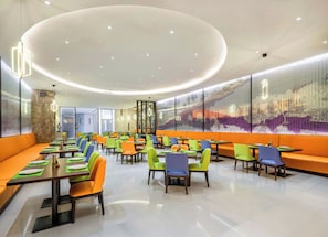 A modern restaurant with a curved ceiling, multiple seating areas, and a large wall mural. - Hampton by Hilton, Yuhang High Speed Railway Station, Hangzhou (Jiaxing)