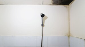 A shower with a hose and a control knob. - Dinda Apartemen Tangerang by Zuzu (Tangerang)
