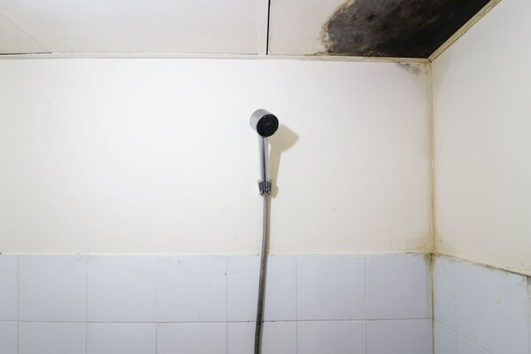 Eine Dusche mit Brausehandstück und Drehregler.