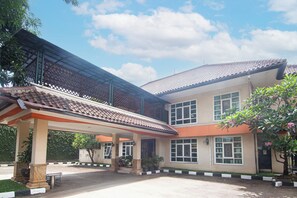 A two-story building with a tiled roof, a covered entrance area, and a paved driveway. - Puri Sawo Manila (Jakarta)