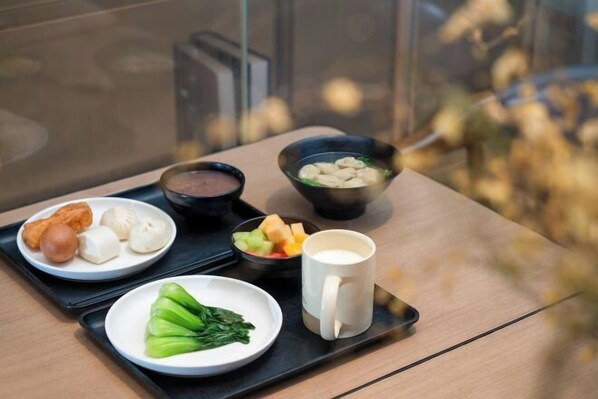 A tray with various food items including dumplings, vegetables, and a bowl of soup. - MeiChen Hotel( within the terminal building of Beijing Daxing International Airport) (Beijing)