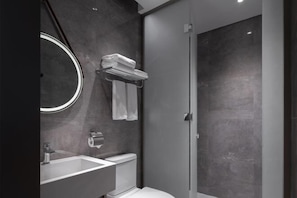 A modern bathroom with a glass shower enclosure, a white sink, and a toilet. - MeiChen Hotel( within the terminal building of Beijing Daxing International Airport) (Beijing)
