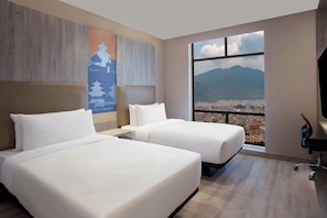 A hotel room with two beds, a large window with a city and mountain view, and a wall with a decorative poster. - Aloft Kathmandu Thamel (Kathmandu)